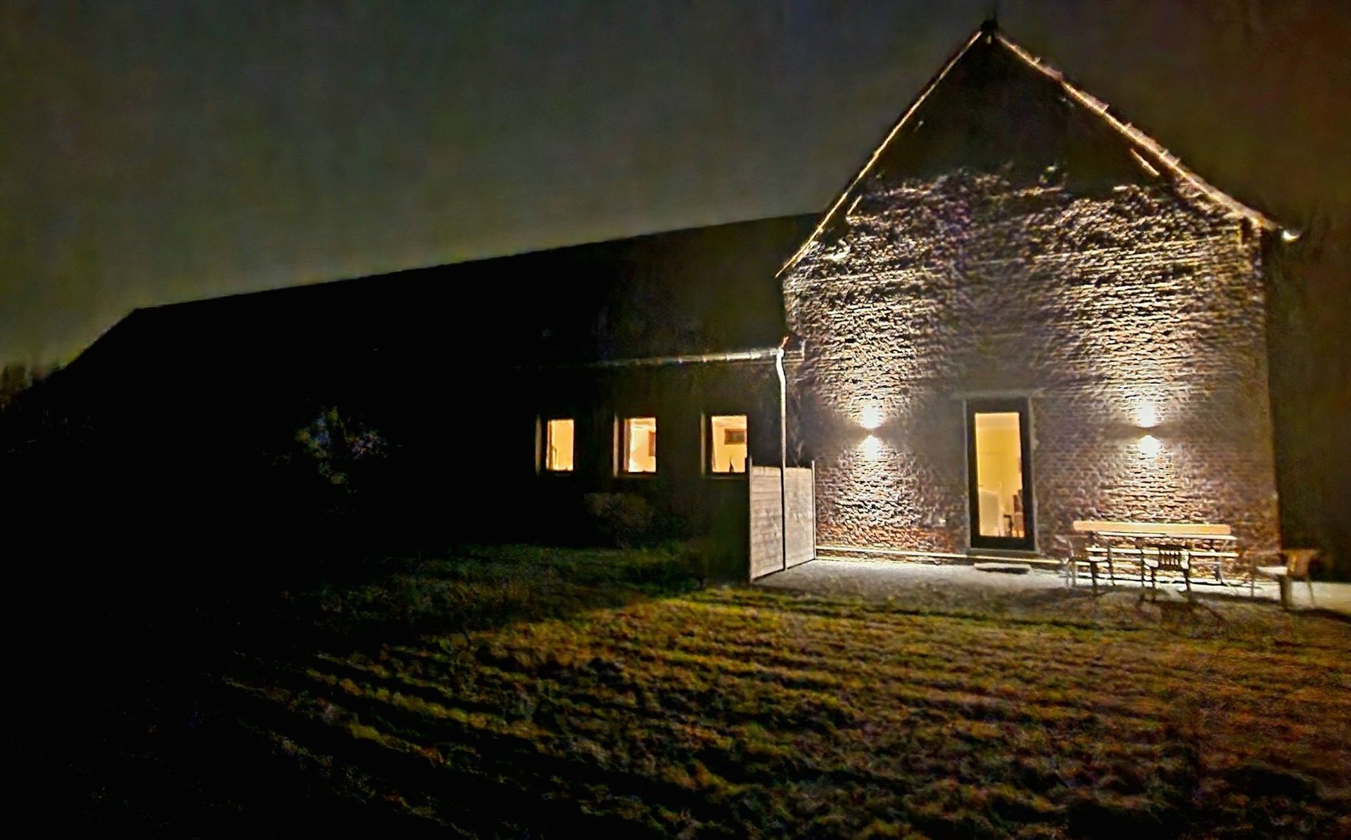 A brick barn and its wall lights at night